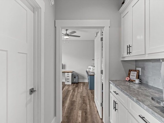 corridor with baseboards and dark wood finished floors