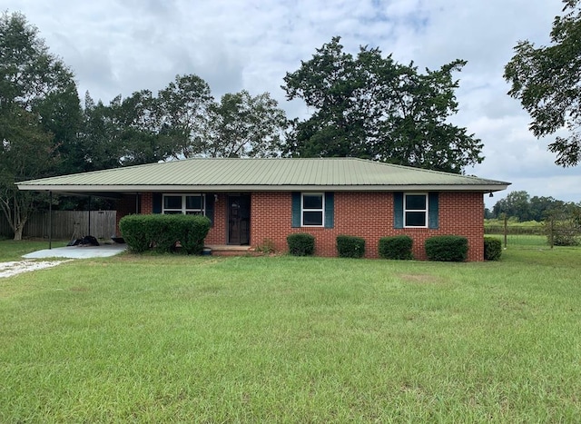 ranch-style house featuring a front yard and a carport