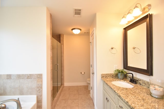 bathroom featuring tile patterned floors, vanity, toilet, and walk in shower