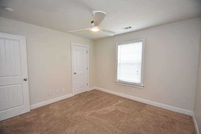 carpeted spare room with ceiling fan