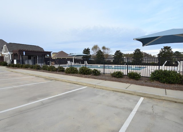 view of vehicle parking with a community pool