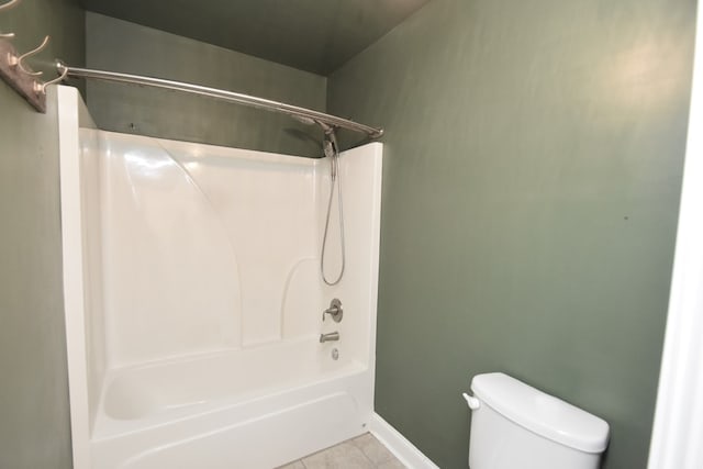 bathroom featuring tile patterned flooring, toilet, and  shower combination