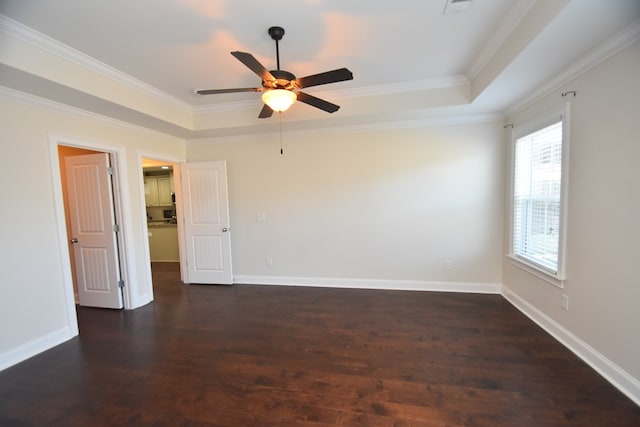 unfurnished room with a tray ceiling, ceiling fan, dark hardwood / wood-style flooring, and crown molding