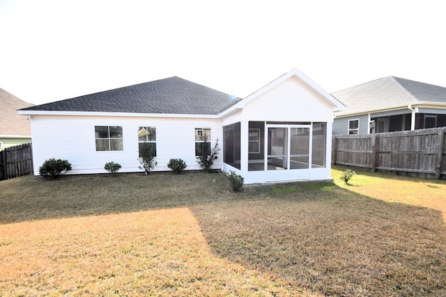 rear view of property with a yard and a sunroom