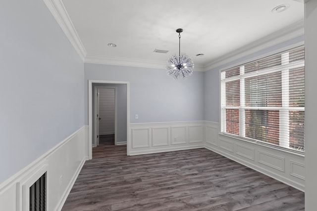 empty room featuring a chandelier, dark wood-type flooring, and crown molding