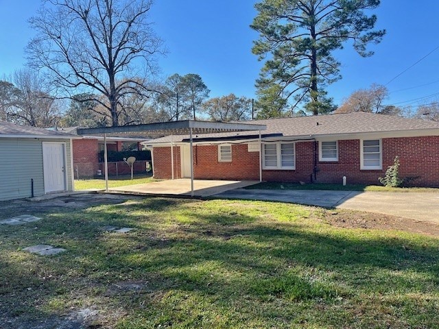 back of house with a patio area and a yard