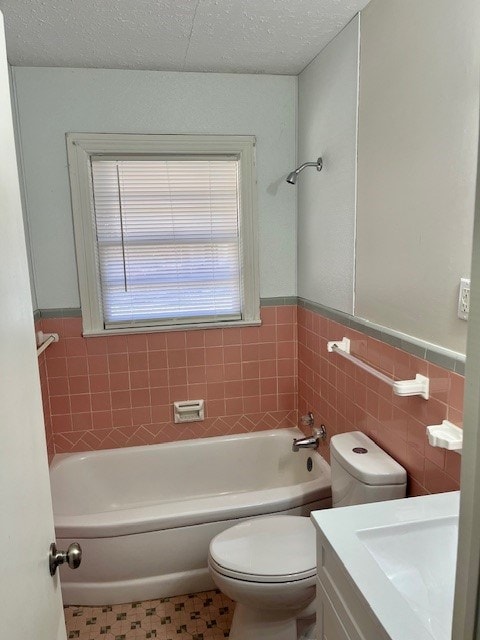 full bathroom with a textured ceiling, toilet, vanity, and a wealth of natural light