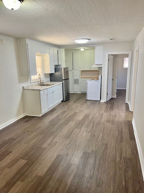 kitchen featuring white cabinetry, stainless steel fridge, dark hardwood / wood-style floors, electric stove, and a textured ceiling