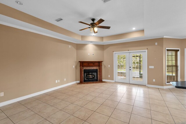 170 County Road 751, Enterprise, AL 36330 - unfurnished living room featuring a raised ceiling, a ceiling fan, french doors, light tile patterned floors, and a tile fireplace