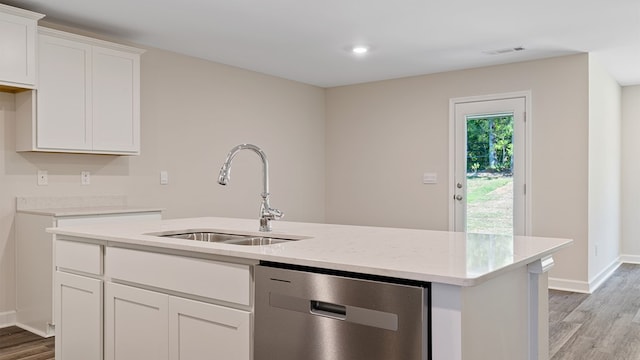 kitchen with light wood-type flooring, white cabinets, sink, dishwasher, and an island with sink