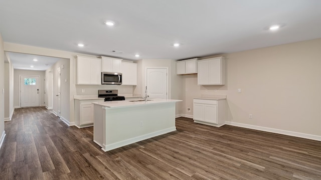 kitchen with white cabinetry, sink, stainless steel appliances, dark hardwood / wood-style floors, and a center island with sink