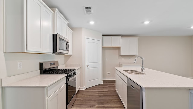 kitchen with a kitchen island with sink, sink, dark hardwood / wood-style floors, appliances with stainless steel finishes, and white cabinetry