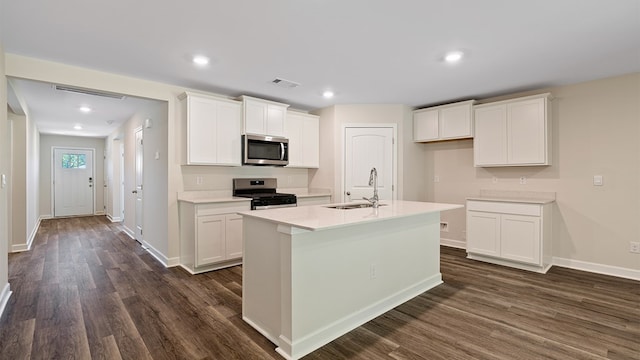 kitchen with white cabinets, sink, stainless steel appliances, and an island with sink