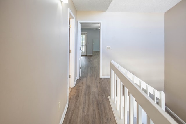 hall with hardwood / wood-style flooring and a textured ceiling