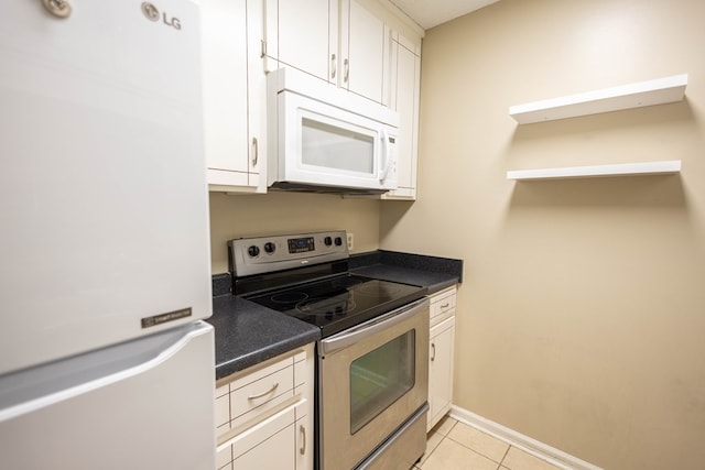 kitchen featuring white cabinetry, light tile patterned flooring, and white appliances