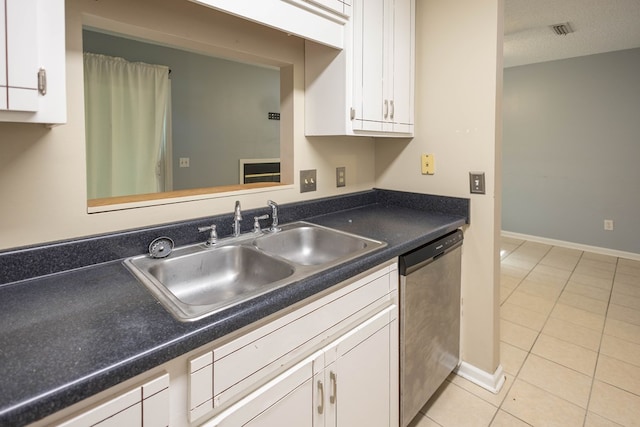 kitchen with white cabinetry, sink, stainless steel dishwasher, a textured ceiling, and light tile patterned floors