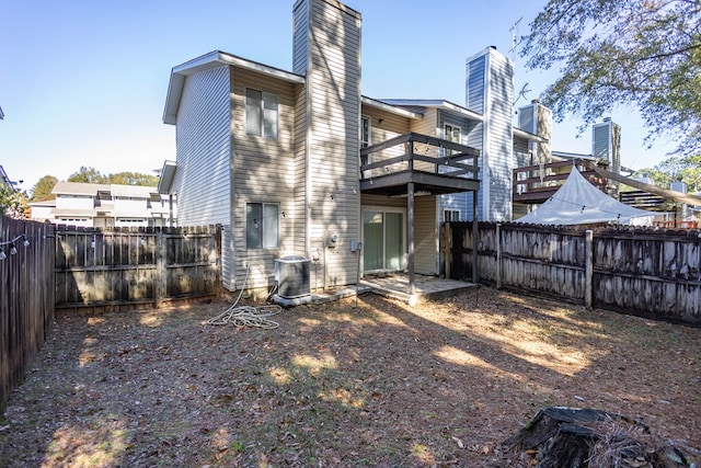 back of house with a balcony and central air condition unit