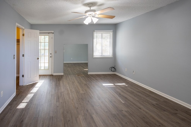 empty room featuring a textured ceiling, ceiling fan, and dark wood-type flooring