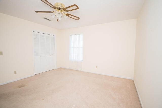 unfurnished bedroom with baseboards, a closet, and light colored carpet
