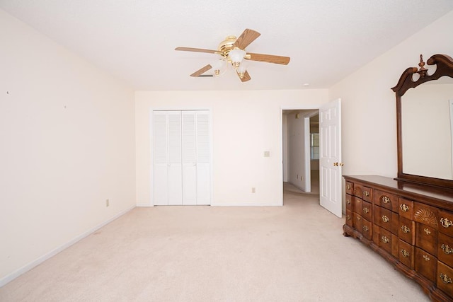 bedroom featuring light carpet, baseboards, a ceiling fan, and a closet