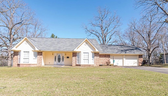 ranch-style home featuring brick siding, a front yard, fence, a garage, and driveway