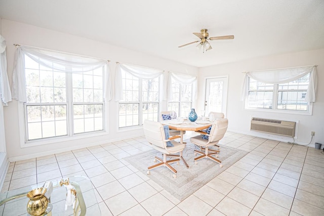 sunroom featuring plenty of natural light, a ceiling fan, and a wall mounted air conditioner