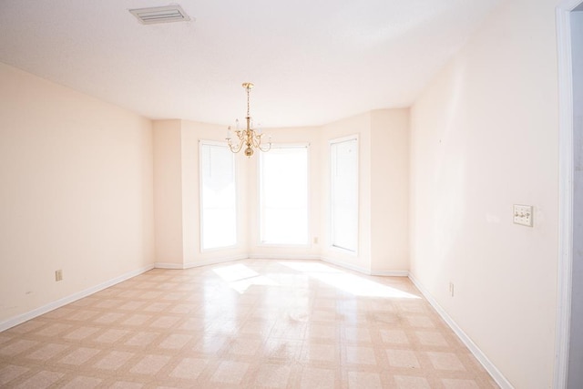 spare room featuring an inviting chandelier, baseboards, visible vents, and light floors