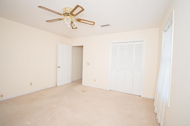 unfurnished bedroom with a closet, light carpet, and baseboards