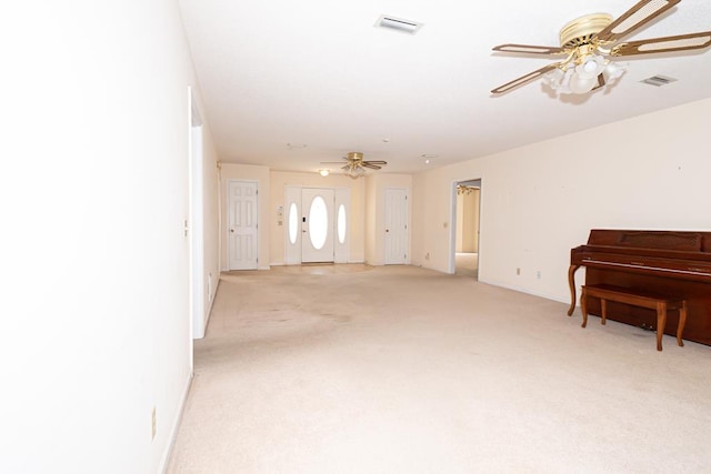 interior space with light carpet, visible vents, and a ceiling fan