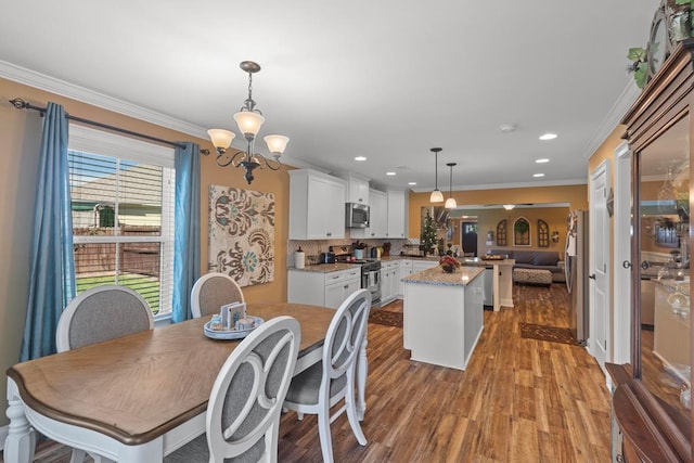 dining space featuring a chandelier, ornamental molding, and light wood-type flooring