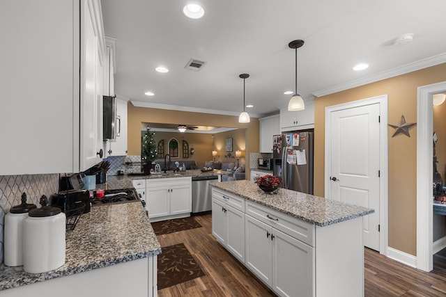 kitchen with white cabinetry, dark wood-type flooring, stainless steel appliances, backsplash, and a kitchen island