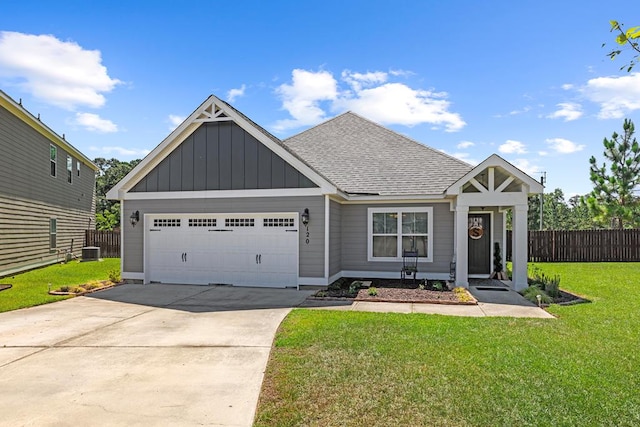 view of front facade featuring a front yard, a garage, and central AC unit