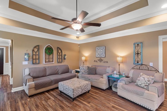 living room with a raised ceiling, crown molding, ceiling fan, and dark hardwood / wood-style floors