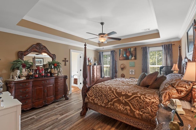 bedroom featuring hardwood / wood-style flooring, a raised ceiling, ceiling fan, and crown molding