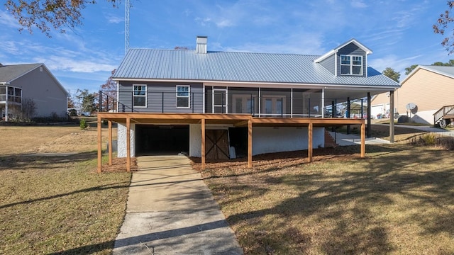 back of property featuring a lawn and a sunroom