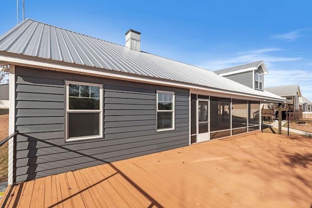 back of property featuring a deck and a sunroom