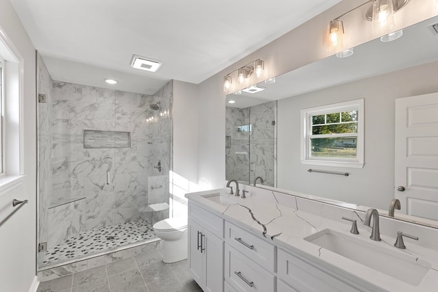 bathroom with vanity, toilet, and a shower with door