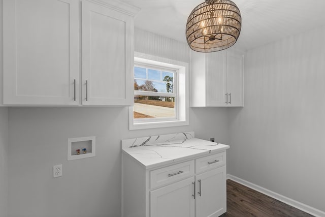 laundry area featuring electric dryer hookup, dark hardwood / wood-style flooring, hookup for a washing machine, and cabinets