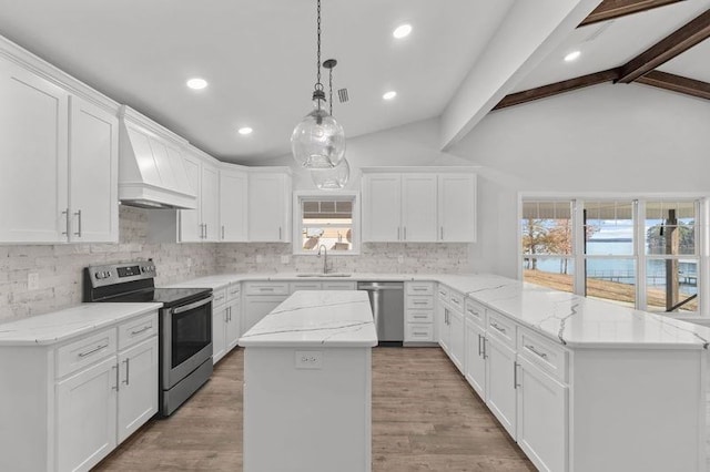 kitchen featuring white cabinets, appliances with stainless steel finishes, a center island, and vaulted ceiling with beams