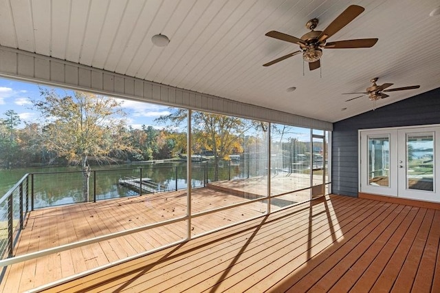 unfurnished sunroom featuring ceiling fan, a water view, and vaulted ceiling