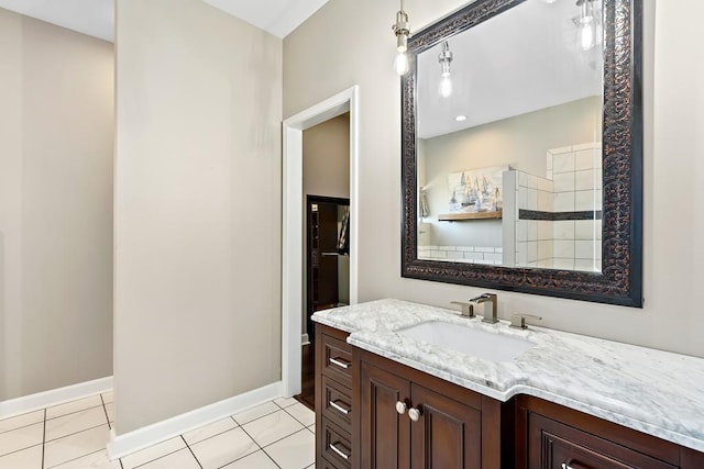 bathroom with tile patterned floors, vanity, and a tile shower