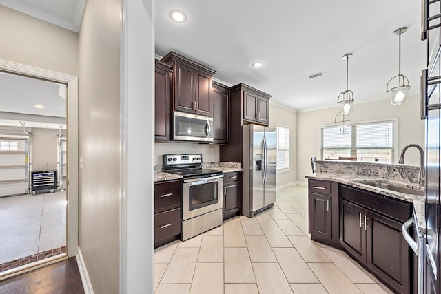 kitchen featuring pendant lighting, sink, appliances with stainless steel finishes, light stone counters, and dark brown cabinetry