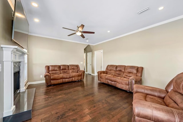 living room featuring ceiling fan, a high end fireplace, dark hardwood / wood-style floors, and ornamental molding