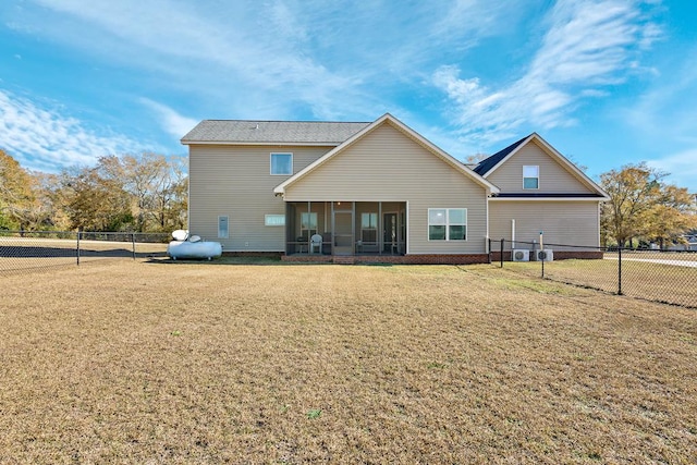 back of house with a sunroom and a yard