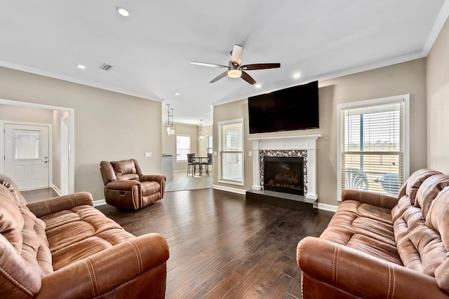 living room featuring ceiling fan, a fireplace, dark hardwood / wood-style floors, and ornamental molding