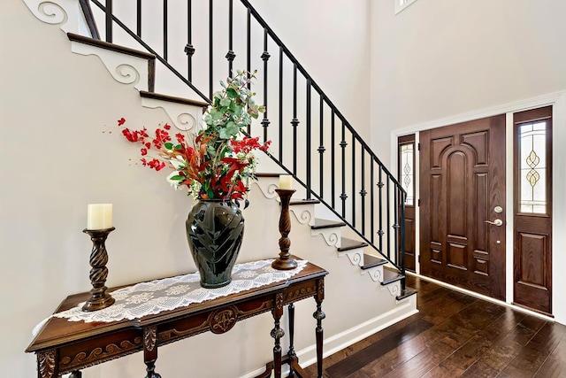 entrance foyer featuring plenty of natural light, dark hardwood / wood-style flooring, and a towering ceiling