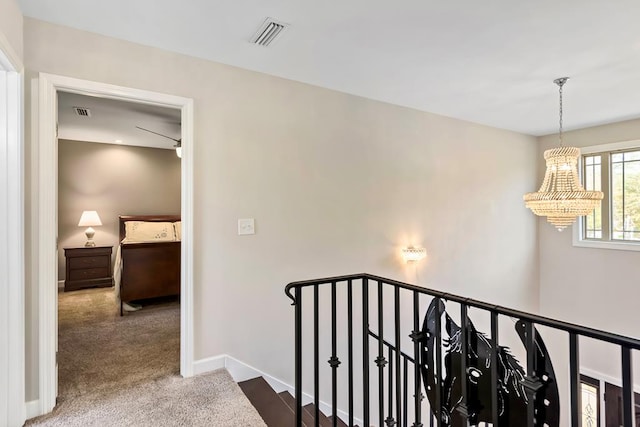 corridor featuring carpet flooring and an inviting chandelier