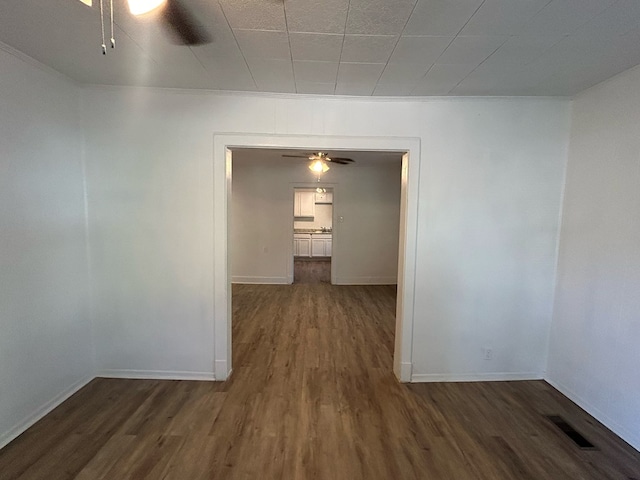 spare room featuring ornamental molding and dark wood-type flooring