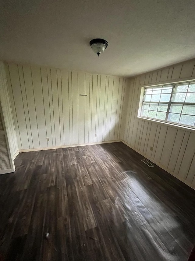 5131 County Rd 417, Kinston, AL 36453 - empty room featuring dark wood-type flooring, baseboards, and wood walls