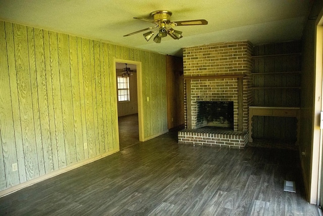 5131 County Rd 417, Kinston, AL 36453 - unfurnished living room featuring a ceiling fan, wood finished floors, wooden walls, a brick fireplace, and a textured ceiling